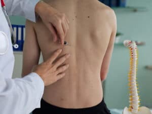 Médico aplicando injeção em coluna de paciente
