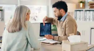 Médico explicando para a sua paciente como funciona a cirurgia de fusão espinhal minimamente invasiva.